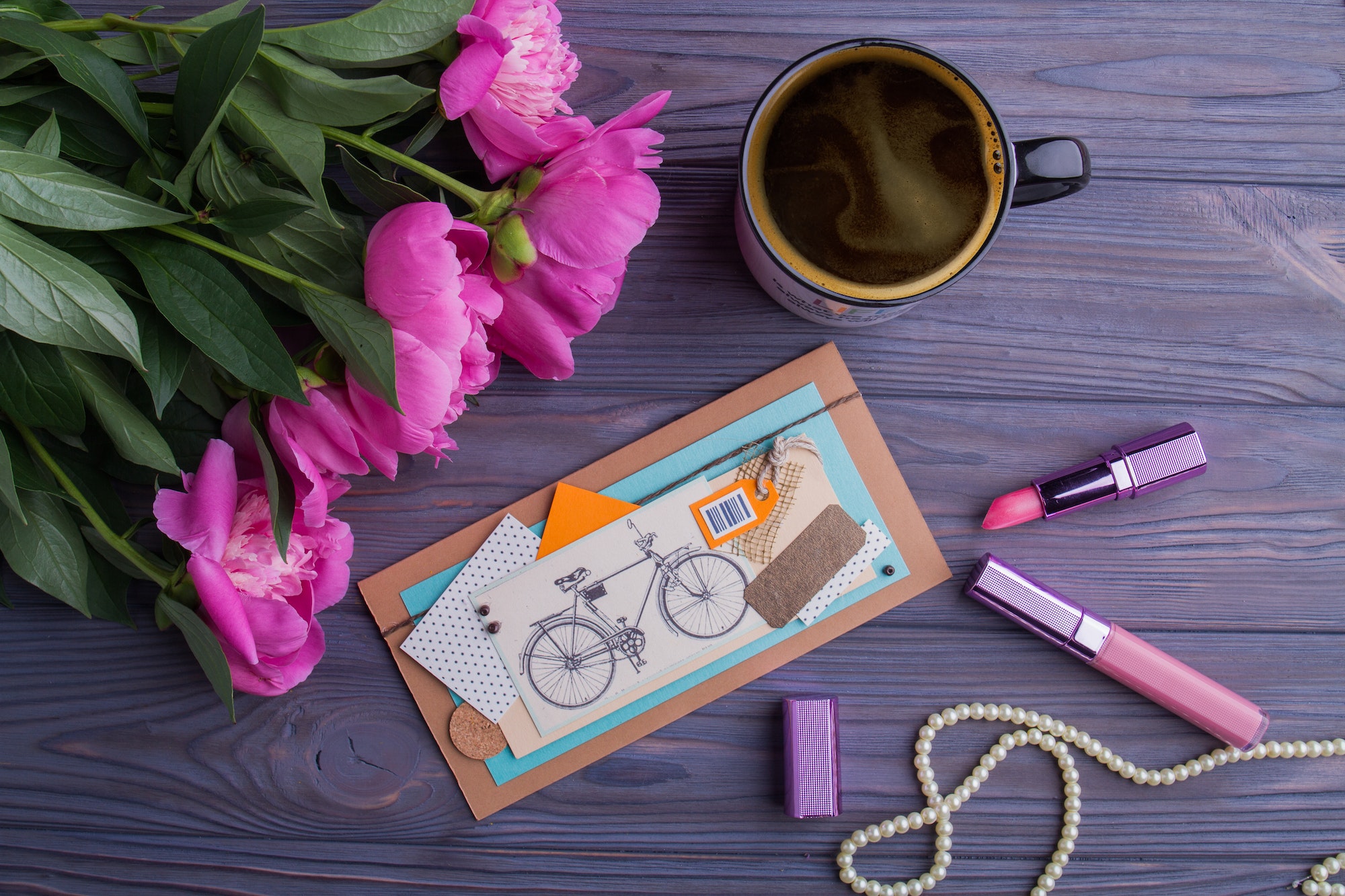 Beautiful female belongings and cup of hot coffee, flat lay.